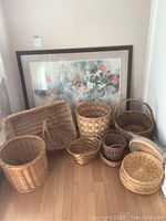 Overall view of floral print and assorted wicker baskets on floor.