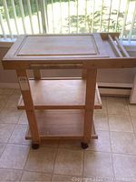 Overall wood kitchen cart showing chopping board top, two shelves, towel rack, and casters