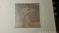 First Jeff Beck vinyl record in a protective plastic sleeve showing Jeff Beck playing guitar under soft lighting.