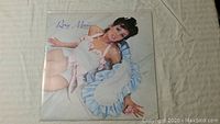 Front cover of the first Roxy Music album vinyl record featuring a woman in a white dress and blue ruffles.