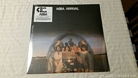 Front cover of ABBA Arrival vinyl record still sealed in plastic wrap, showing the band inside a dome.