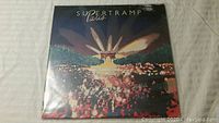 Front cover of Supertramp 'Paris' vinyl album showing art with crowd and stage lights.
