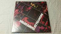 Front cover of the Miles Davis vinyl album 'At Fillmore' showing the album title and concert photo collage artwork.
