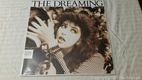 Front cover of Kate Bush's The Dreaming vinyl album showing Kate Bush with chains and dramatic makeup.