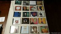 40 CD albums laid out in jewel cases, showing front covers, some recognizable artist images