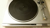 Close-up of the turntable platter, tonearm, and control panel.