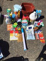 Overview of all cleaning items arranged on the ground including liquid cleaners, wipes, sponges, brushes, gloves, and plastic tubs.