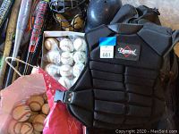 Wide view showing the full collection of baseball bats, gloves, protective gear, helmets, and baseballs, both loose and boxed.