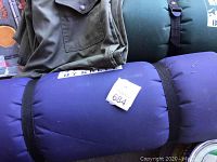 Stack of rolled sleeping mats and folded green shirt