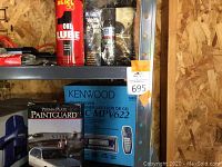 Shelf showing Kenwood CD receiver KDC-MPV622 in box, Perma-Plate Paintguard box, and Slick 50 One Lube can against a plywood wall background.