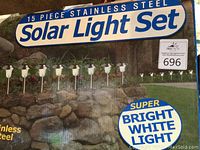 Photo of set packaging showing 15-piece stainless steel solar light set with branding and features.
