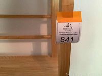 Close-up of natural light wood finish and structural wooden doweling across back of shelving unit