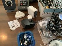 Photo showing earbuds, charging adapters and cords on a table.