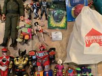Wide view showing vintage action figures from multiple franchises, including Power Rangers, X-Men, and Transformers, with a Creative Years drawstring bag.