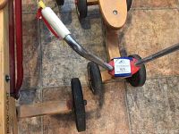 Top down image showing part of the ride-on bike frame, wheels, and handle with visible label