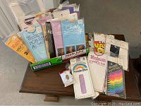 Photo showing multiple unopened vintage pantyhose packages in a box and loose, various brands and colors.