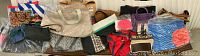 Photo showing a variety of handbags, duffle bags, and gift bags arranged on a surface.