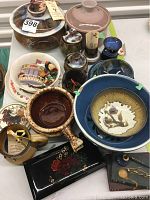 Full assortment of pottery and related items arranged on a table, showing bowls, mugs, plates, bakeware with lids, and wooden decorative items.