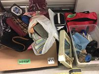 Wide shot of assorted bathroom items and storage cabinet, cosmetic bags, and car emergency kit bag