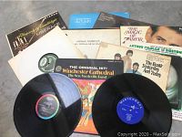 Photo of all 8 albums with some vinyl records partly removed showing labels.