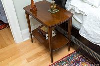 Single side table showing top surface with some scratches and decorative grooved legs