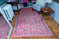 Full view of rug laid on tiled floor beneath furniture