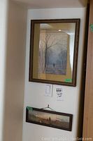 Framed watercolor paintings hanging on wall, showing full view of both artworks and frames.