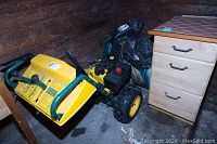 Full side angle of the yellow and green Yardman snowblower showing the intake chute, large tires, and control levers.