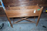 Wood planter box with visible scratches, nicks, and cross bracing support