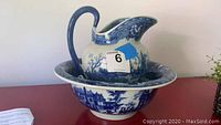 Full view of blue and white ironstone pitcher inside matching basin showing tops and handles