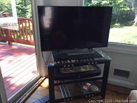 Sony flat screen TV on black wood corner stand in room