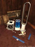 All four items arranged on carpet: heater, humidifier, fan and trimmer base