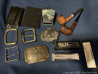 Overview of all items including pipes, belt buckles, wallets, lighter, and harmonica