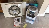 Photo showing Sears window fan, Lasko evaporative humidifier, and Honeywell wireless doorbell boxed together