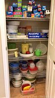 Closet shelf with additional food storage bag boxes and plastic containers, some partially opened or filled.