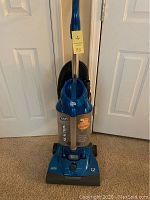 Front full view of blue Dirt Devil Reaction bagless vacuum cleaner showing handle and dustbin.