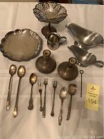 Full view of the lot including serving tray, candy dish, creamer, candlesticks, and assorted spoons and forks