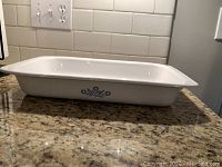 Side view of white Corning Ware roasting pan with vintage Cornflower Blue floral design on the side.