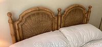 Front view of the queen-sized headboard with detailed wicker weaving, showing its cottage coastal style and curved finish.