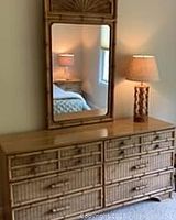 Full view of the wicker rattan dresser with mirror on top, showing dresser's surface and drawer arrangement.