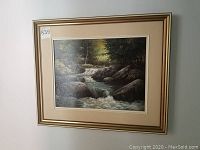 Framed signed original oil painting depicting a creek with rocks and trees, showing the full artwork and frame.