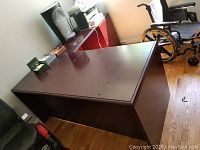 Wooden office desk front and top corner showing surface wear and overall desk size