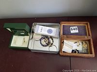 Overall lot with green Rolex watch box on left, metal tin with assorted jewelry in center, wooden box with small pieces on right