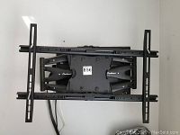 Full view of the EverMount black metal television wall mount with articulating arms and dual vertical rails.