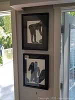 Two framed artworks hanging on wall, showing black and white human figure drawings.