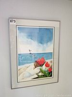 Framed original Caroline Millard watercolour painting showing birds flying over beach with tulips and horseshoe.