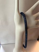 Blue crystal choker necklace shown on a mannequin hand from two angles.