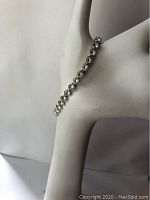 Photo showing the full bracelet elegantly draped on a display hand, highlighting the linked crystals with a silver-tone setting.