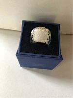 Top view of Swarovski crystal ring in blue box on white background.