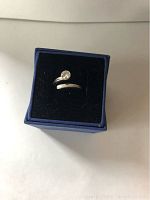 Silver spiral solitaire Swarovski ring displayed in blue box with black velvet interior.